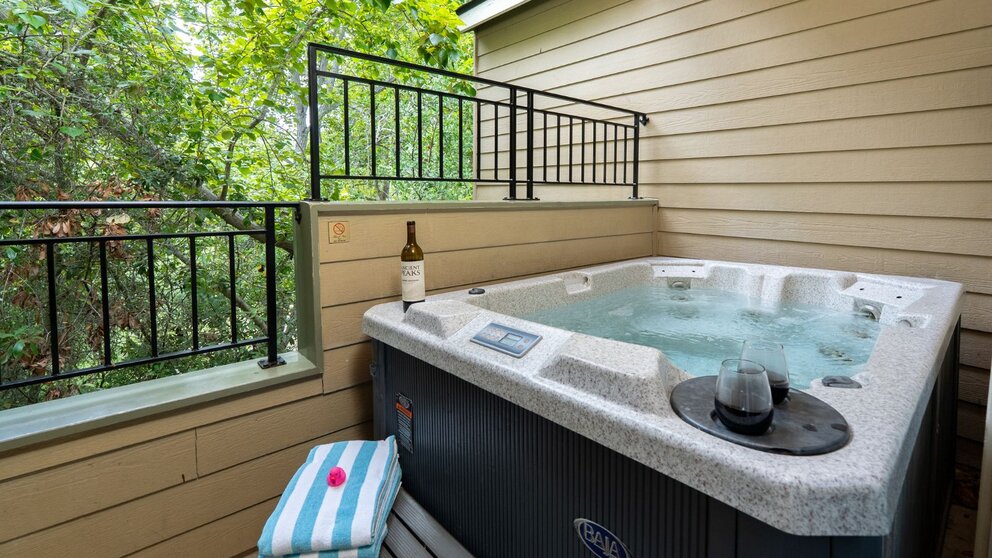 a hot tub with a bottle of wine on the side
